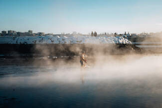 A man is seen walking into the ocean amid rising steam.