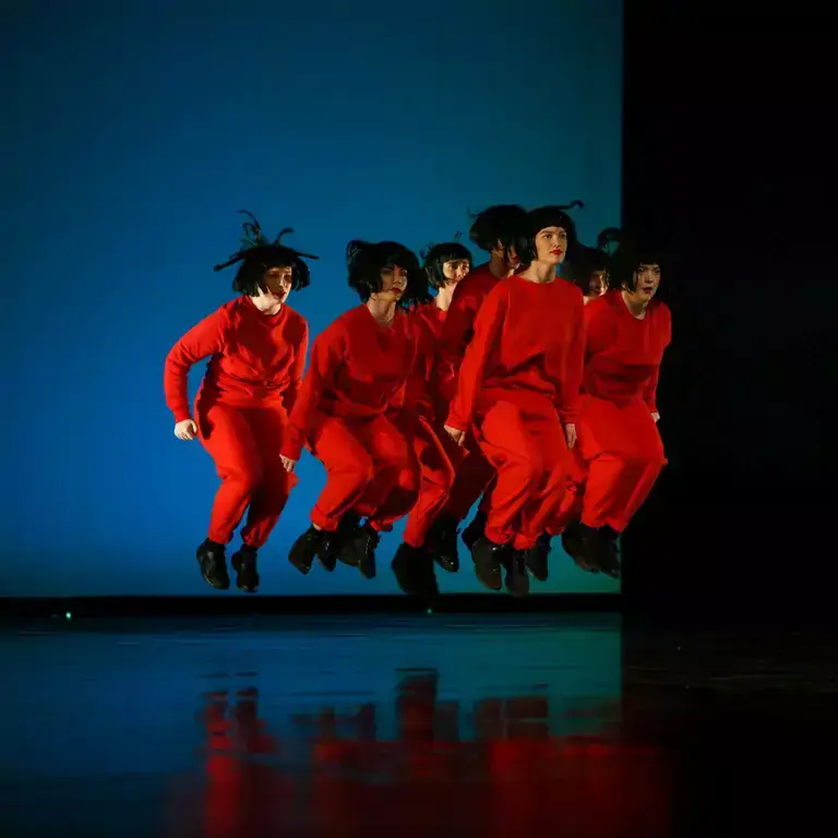 People in red outfits jumping at the same time