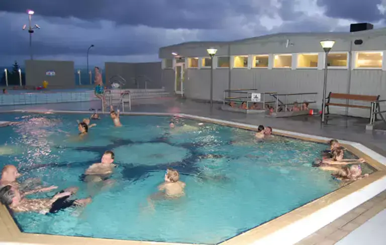 people in Seltjarnarnes pool at night