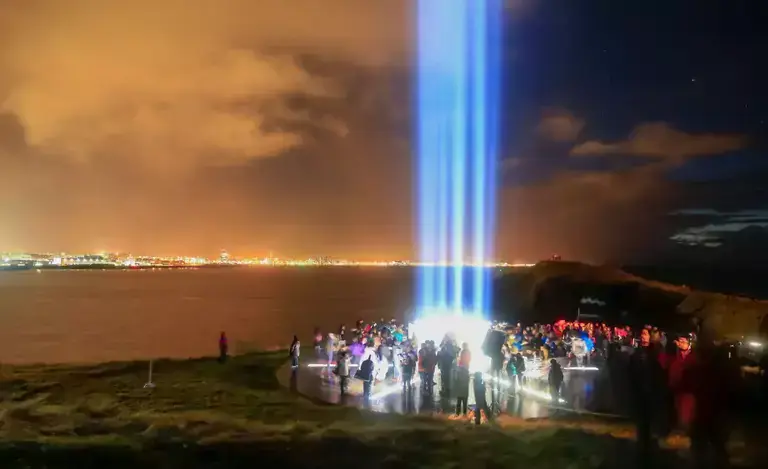 Imagine peace tower light beam at night with people