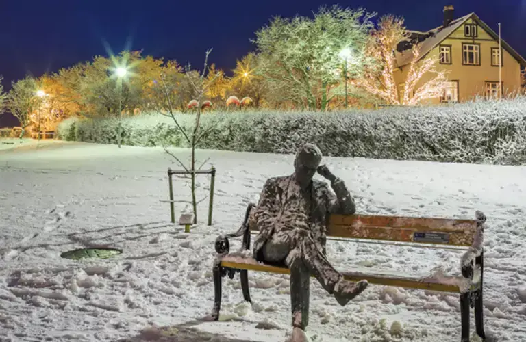 Statue of a man sitting on a bench