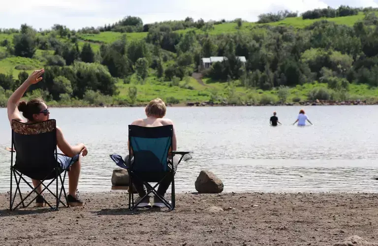 People sitting by Hvaleyrarvatn lake