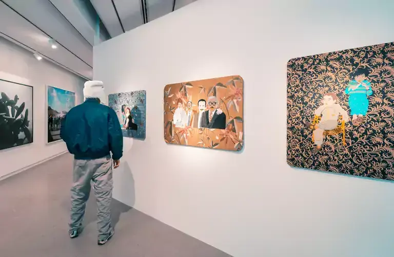 A man lookinng at paintings