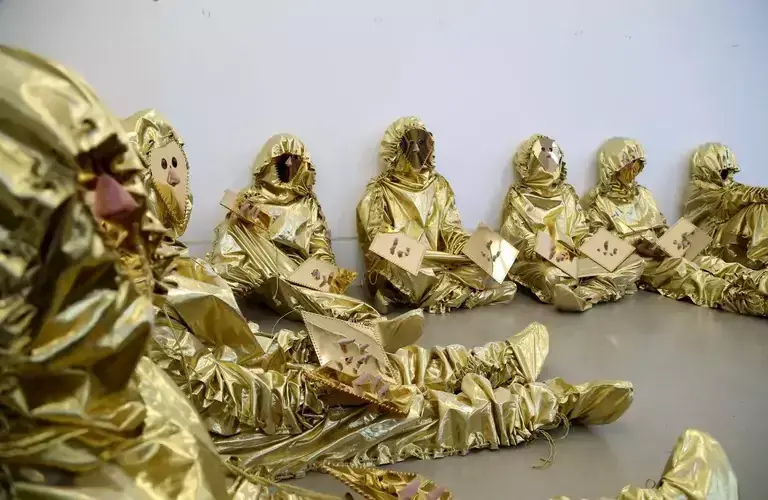 People in golden suits as a part of an artwork